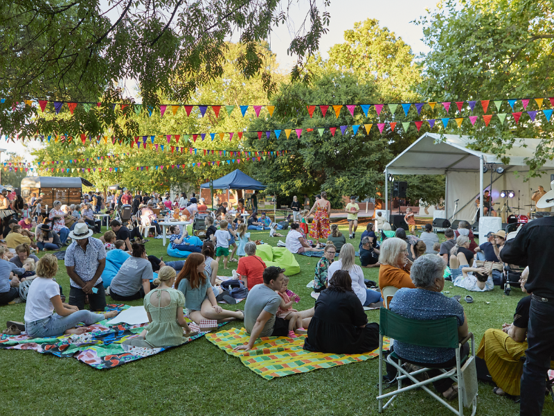 Image of people sitting on grass listening to music