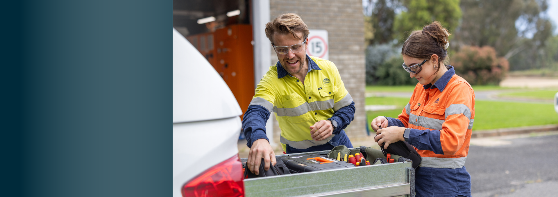 Budget Slider 25/26 - Man and Woman in Hi-Vis Work gear loading drawer in the back of a ute.