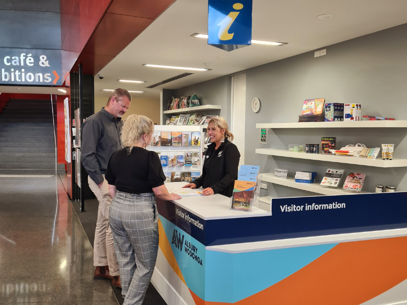 Two people getting information from the Albury Wodonga Visitor Information Centre