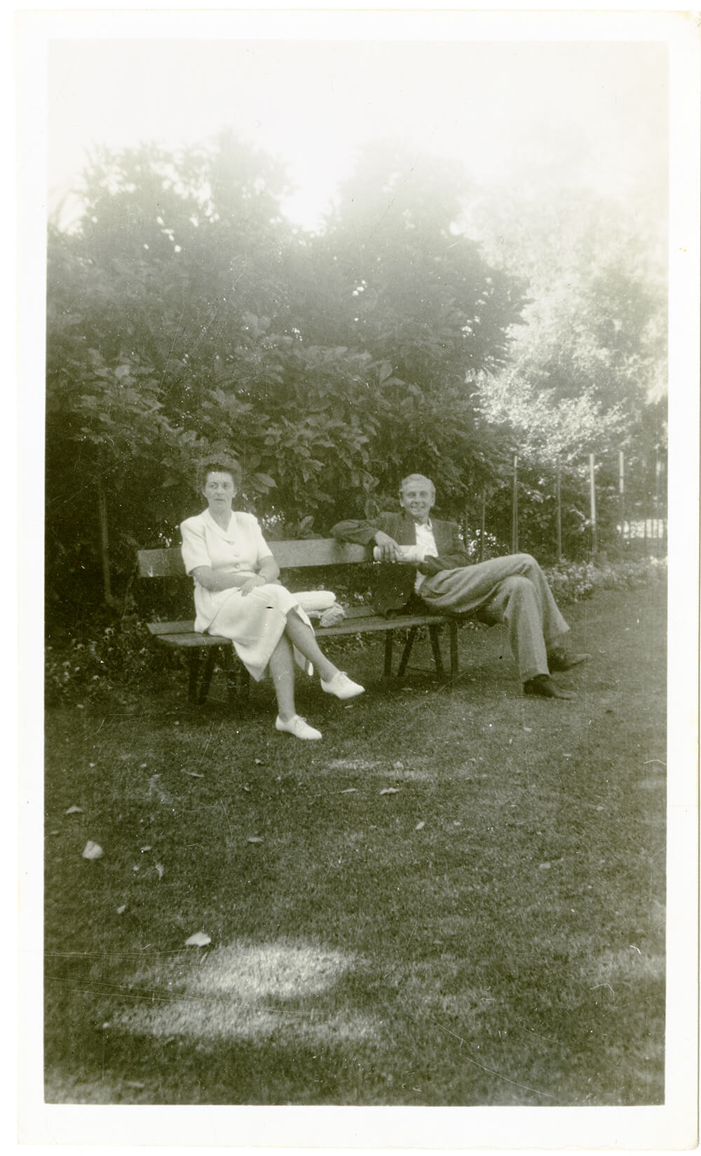Man and woman seated on a park bench at Albury Botanic Gardens, 1950. ARM 97.977